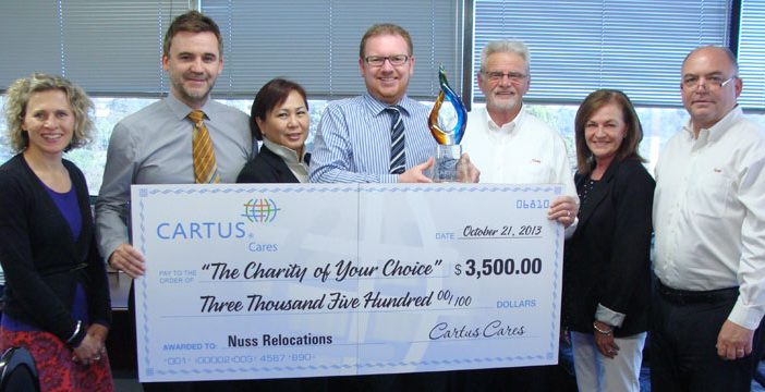 Nuss employees holding a giant Cartus Cares giant cheque and trophy