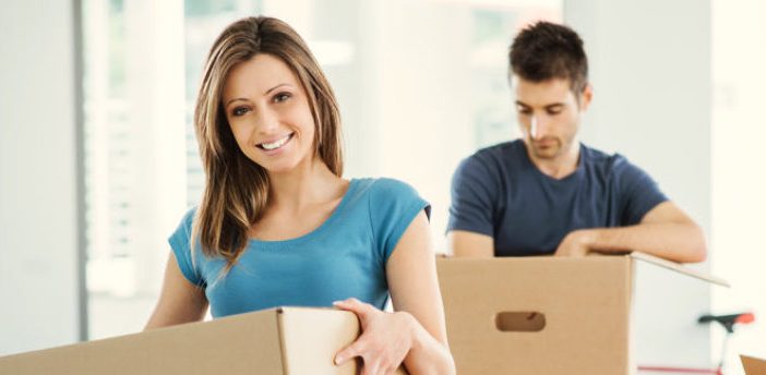 young couple packing boxes for moving overseas