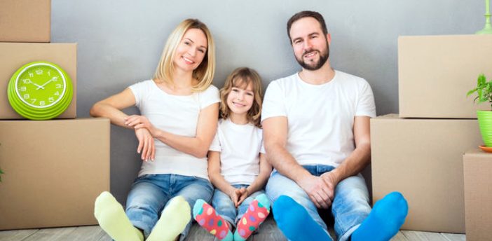 Family sitting on floor with moving boxes