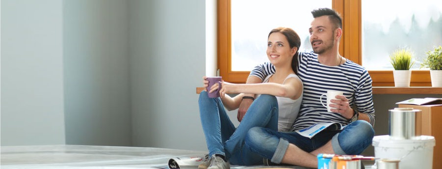 Young couple sitting on floor after moving house